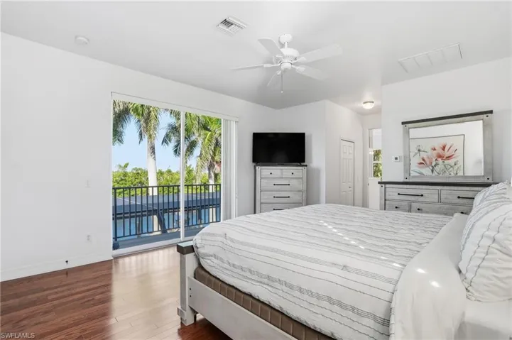 Bedroom featuring access to outside, dark wood-style floors, a closet, and ceiling fan