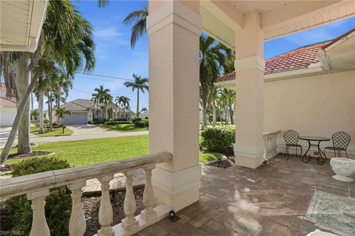 Covered porch featuring a residential view and a lawn