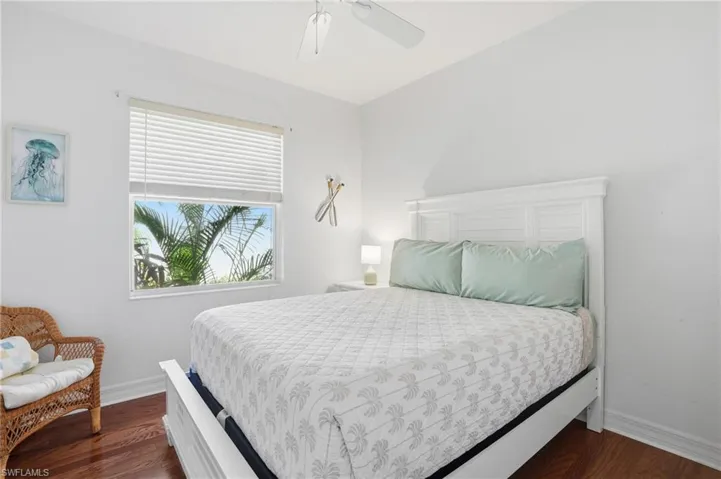 Bedroom featuring a ceiling fan and dark wood-style flooring