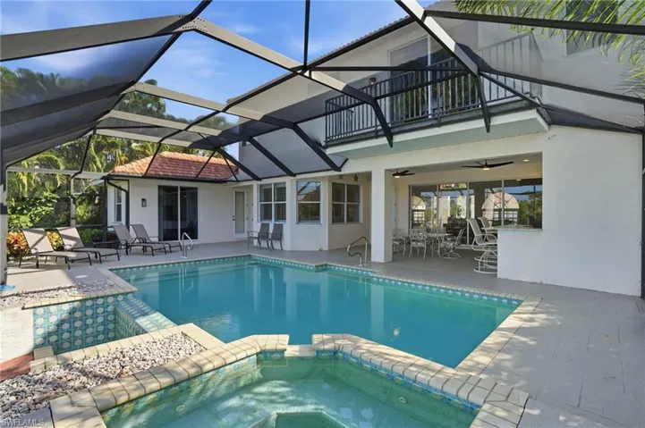 View of pool featuring a sunroom, a pool with connected hot tub, and a patio area