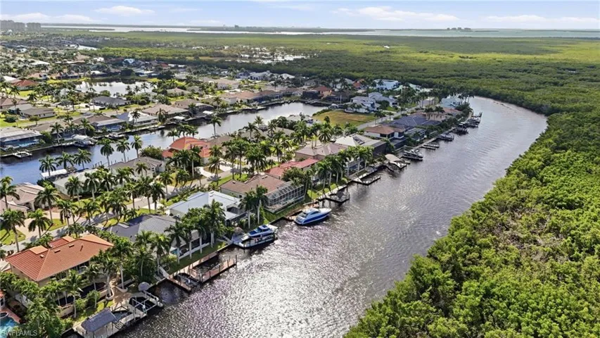 Aerial perspective of suburban area featuring a nearby body of water