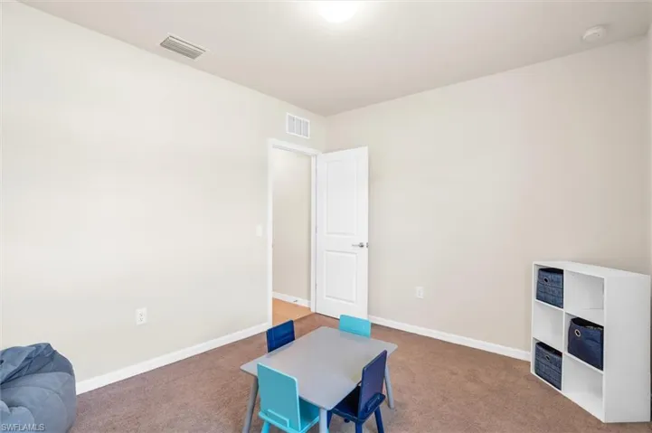 Recreation room featuring carpet floors and baseboards