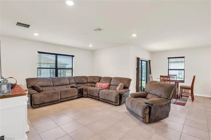 Living area with plenty of natural light, recessed lighting, and light tile patterned flooring