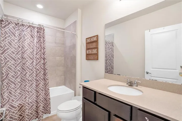 Full bathroom featuring vanity, shower / bath combination with curtain, and tile patterned floors
