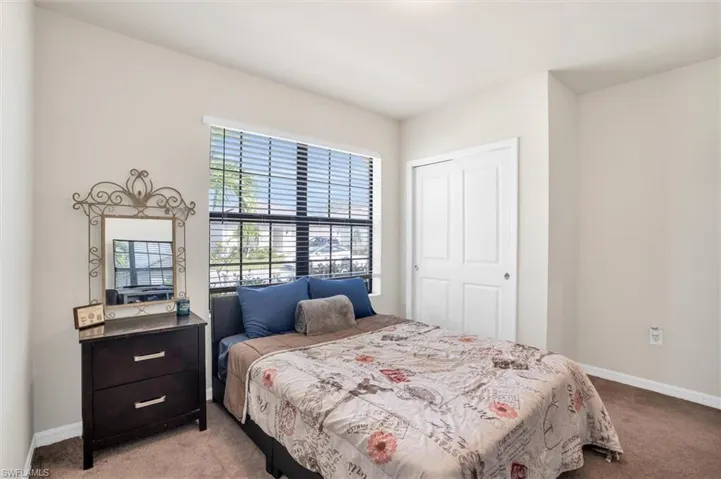 Bedroom with light carpet and a closet