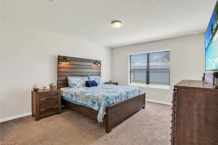 Bedroom featuring carpet and baseboards