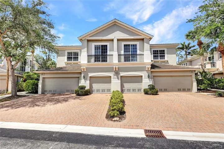 View of front of home with a garage, a balcony, decorative driveway, and stucco siding