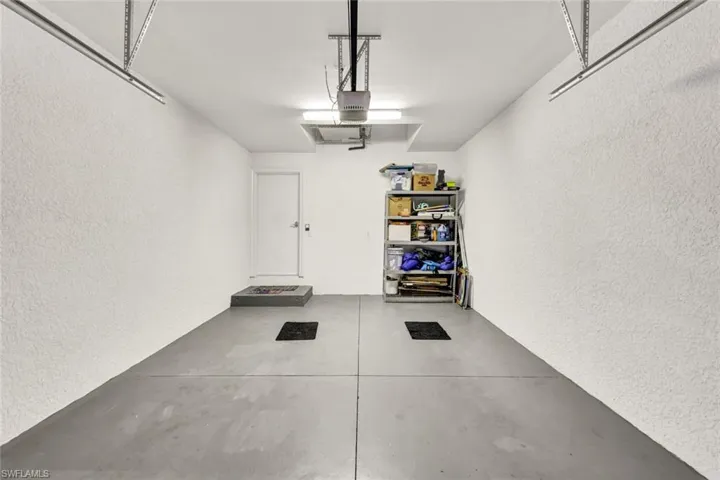 Garage featuring a textured wall and a garage door opener