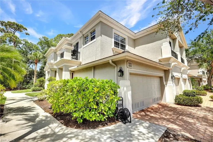 View of home's exterior featuring a balcony, decorative driveway, an attached garage, and stucco siding