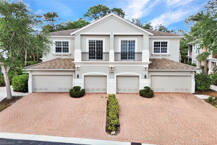 View of front of property featuring stucco siding, decorative driveway, and a garage