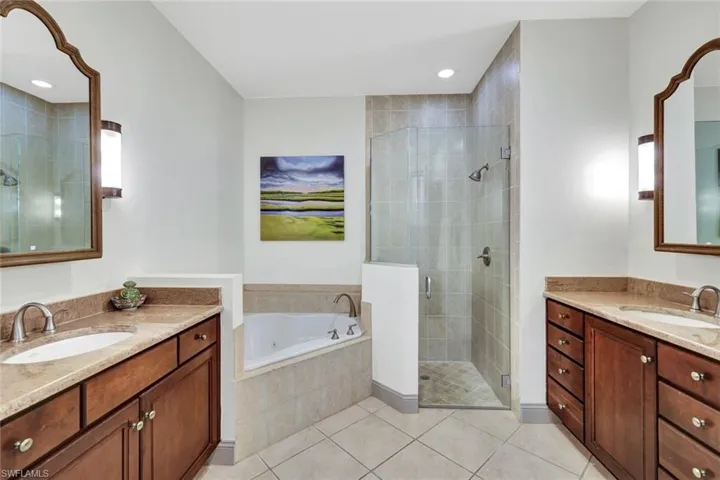Full bath featuring a garden tub, a sink, a stall shower, and tile patterned floors