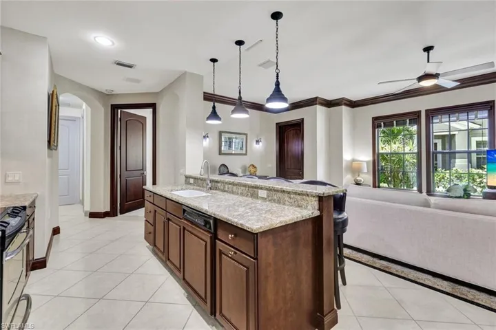 Kitchen with a sink, open floor plan, visible vents, arched walkways, and stainless steel range oven