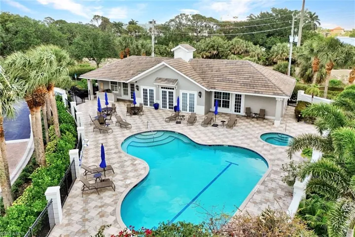 Community pool featuring a community hot tub, fence, a patio area, and french doors