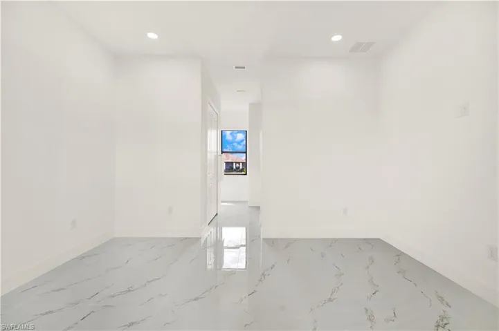 Spare room featuring recessed lighting and light marble finish flooring
