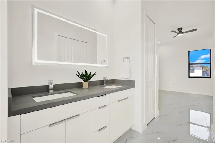 Bathroom with double vanity, light marble finish flooring, a ceiling fan, and recessed lighting