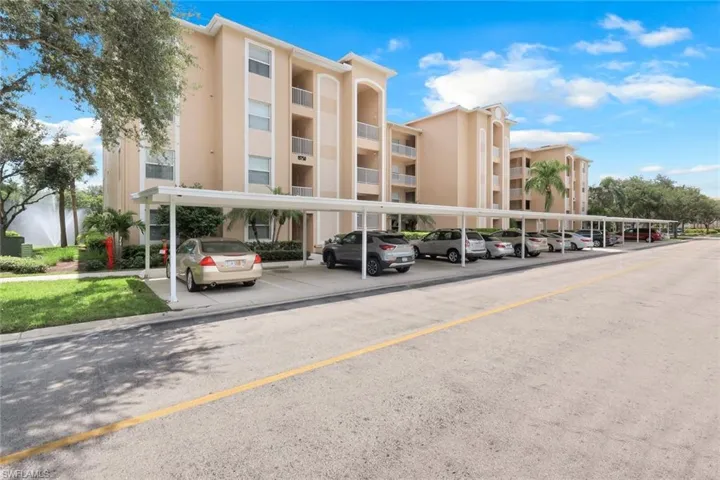 View of apartment building / complex with covered parking