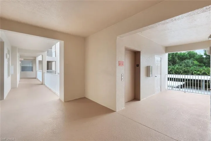 Corridor featuring a textured ceiling and elevator