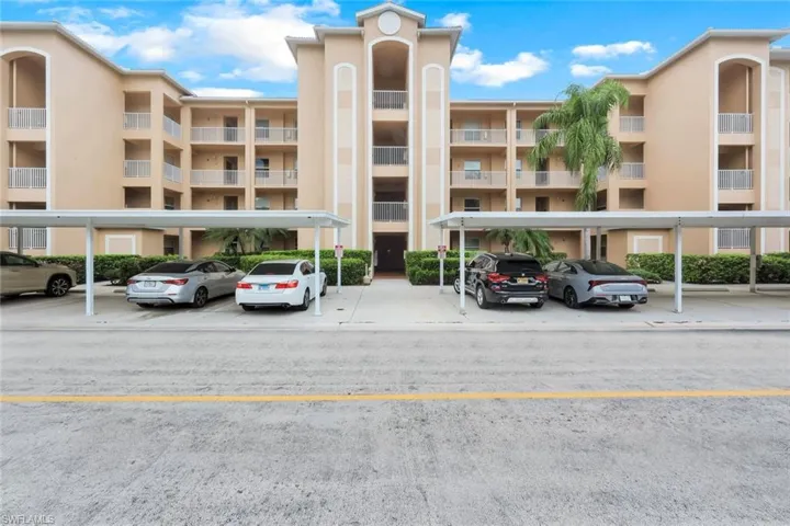 View of apartment building / complex with covered parking