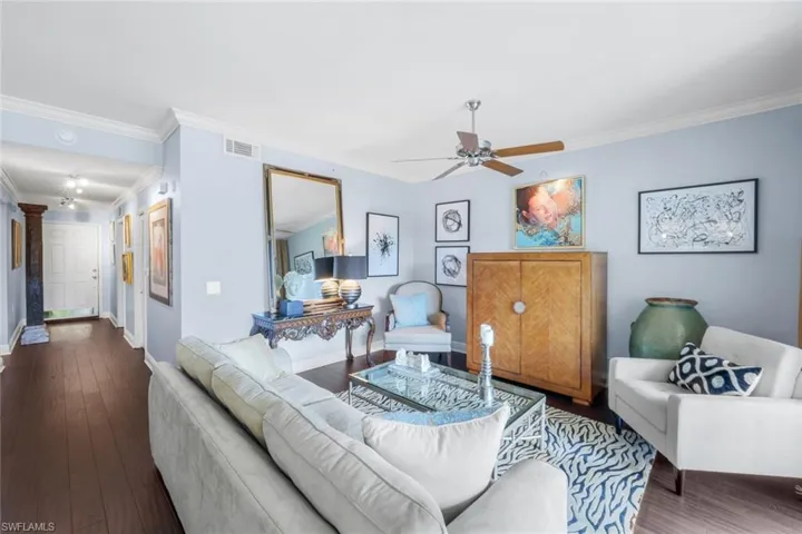 Living area featuring crown molding, wood finished floors, and a ceiling fan