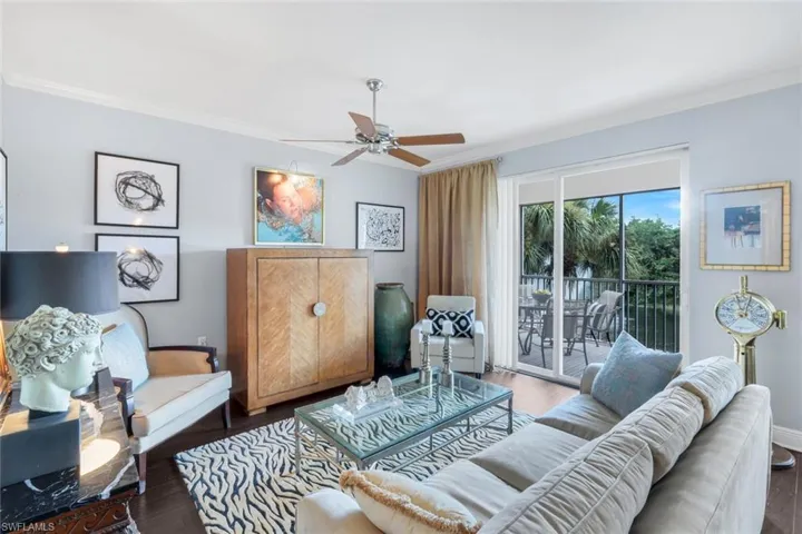 Living area with ornamental molding, wood finished floors, and ceiling fan