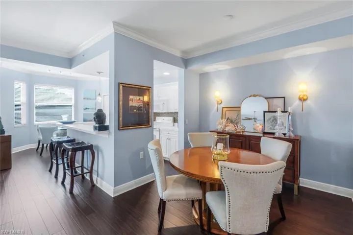 Dining space with crown molding, dark wood finished floors, and recessed lighting
