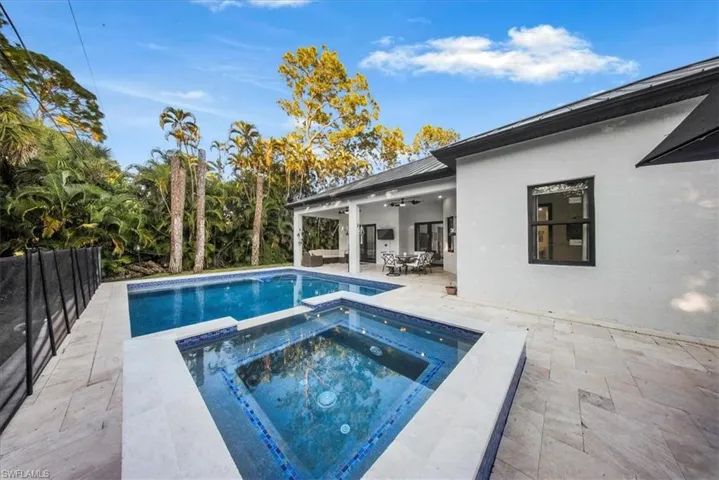View of pool with a patio, a pool with connected hot tub, and outdoor dining area