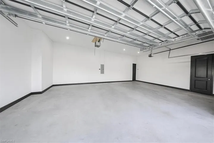 Garage with electric panel and baseboards
