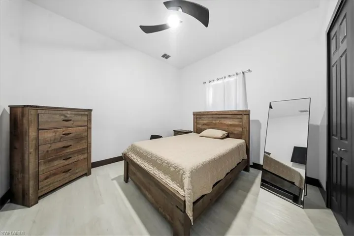 Bedroom featuring vaulted ceiling, a ceiling fan, and light wood-type flooring