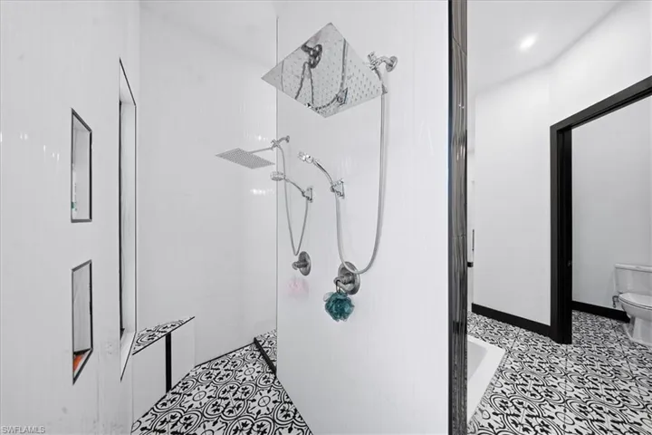 Bathroom featuring tiled shower and toilet