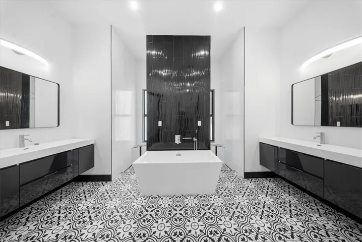 Bathroom with a soaking tub, two vanities, and a walk in shower