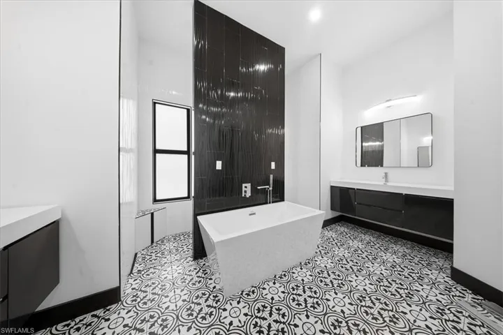 Full bathroom with vanity, a soaking tub, and a walk in shower