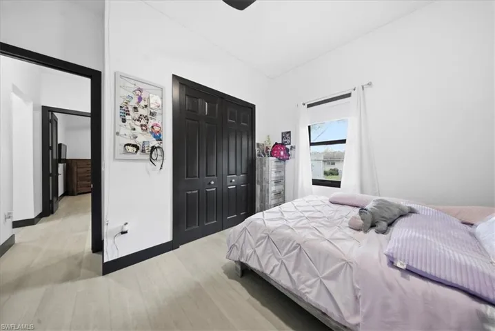 Bedroom with a closet, light wood-type flooring, and a ceiling fan
