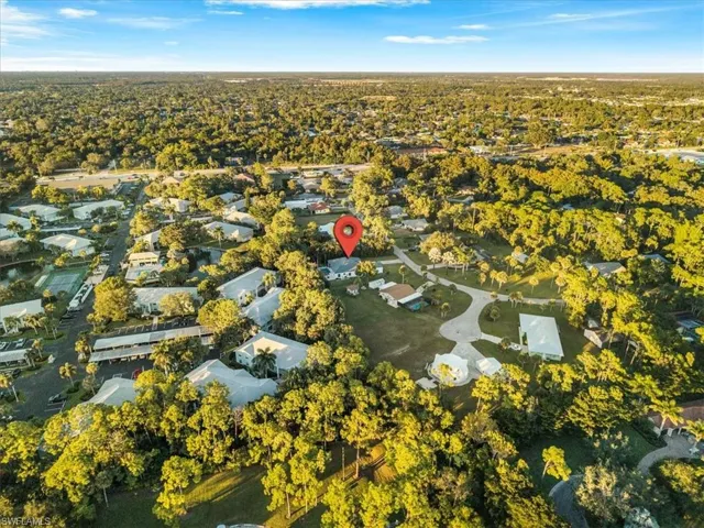 Aerial overview of property's location with nearby suburban area and a tree filled landscape