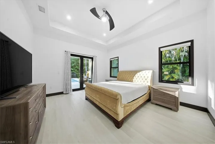 Bedroom with access to outside, light wood-style flooring, a ceiling fan, and french doors