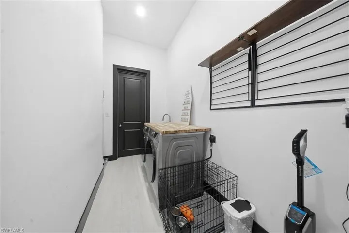 Laundry room with independent washer and dryer and light wood-style flooring