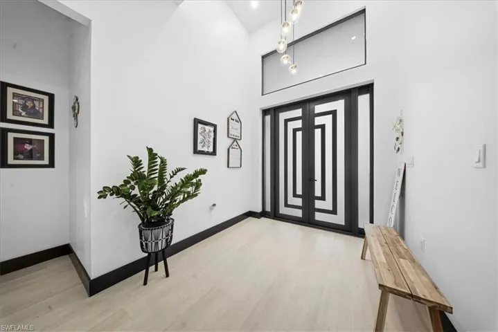Entrance foyer featuring light wood-type flooring and a towering ceiling