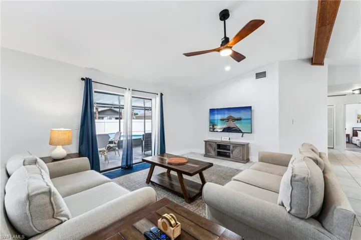 Living area with ceiling fan, lofted ceiling, recessed lighting, and light tile patterned flooring