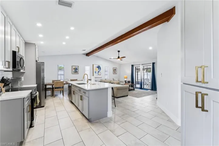 Kitchen featuring appliances with stainless steel finishes, gray cabinets, a sink, plenty of natural light, and recessed lighting