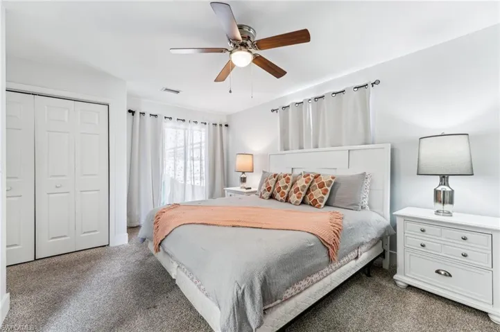 Carpeted bedroom featuring a closet and a ceiling fan