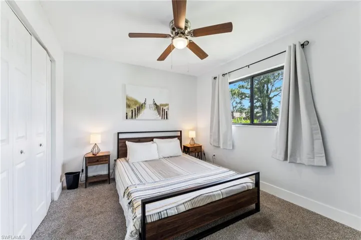 Bedroom with a closet, carpet flooring, baseboards, and a ceiling fan