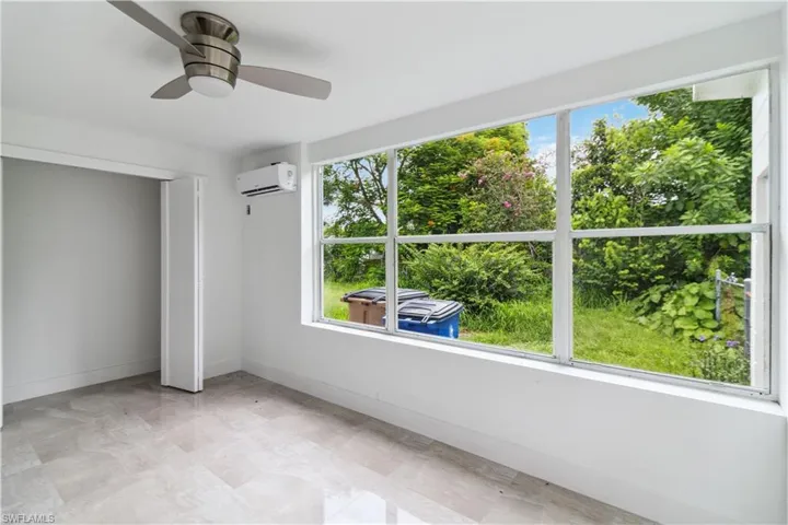 Unfurnished bedroom featuring a closet, a wall unit AC, and ceiling fan