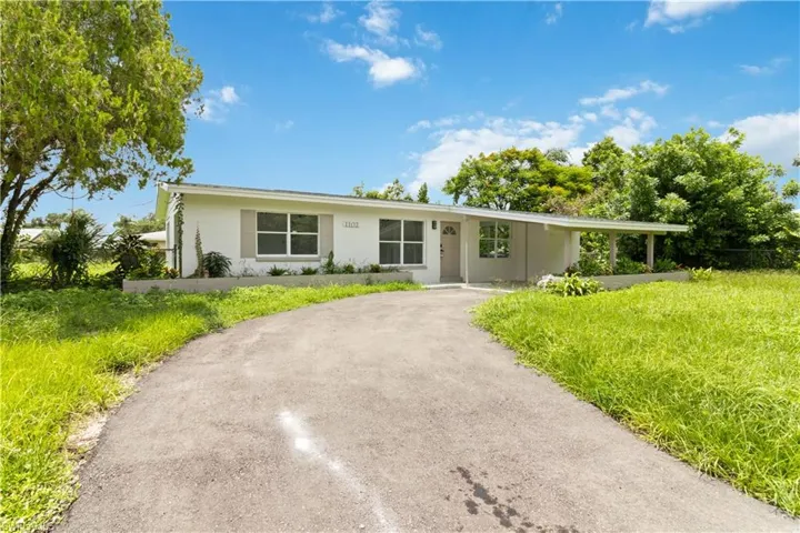 Ranch-style house featuring a front yard and a carport