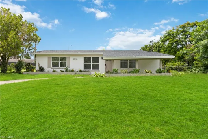 Ranch-style home featuring a front lawn