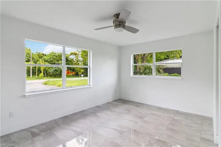 Unfurnished room with ceiling fan and a healthy amount of sunlight