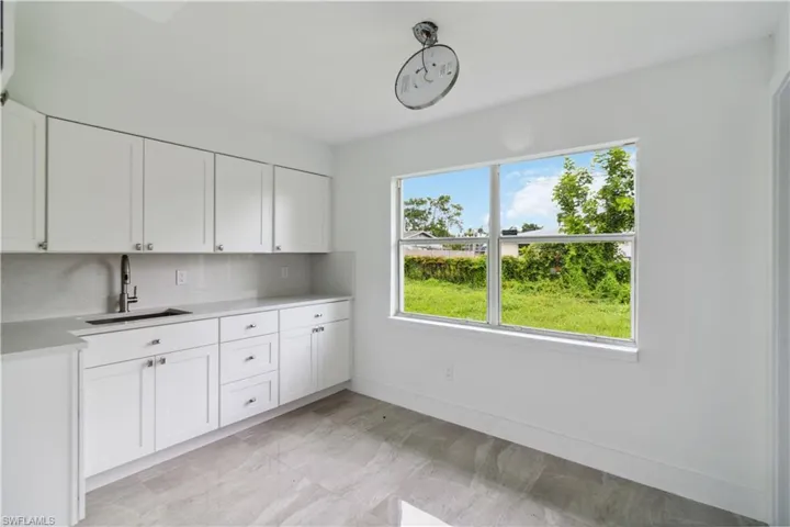 Kitchen with white cabinetry, tasteful backsplash, and sink