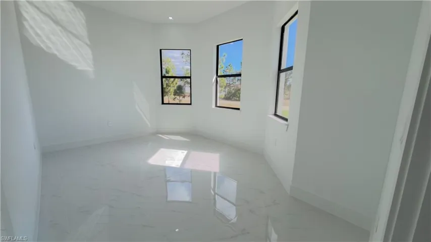 Empty room with light marble finish floors and plenty of natural light
