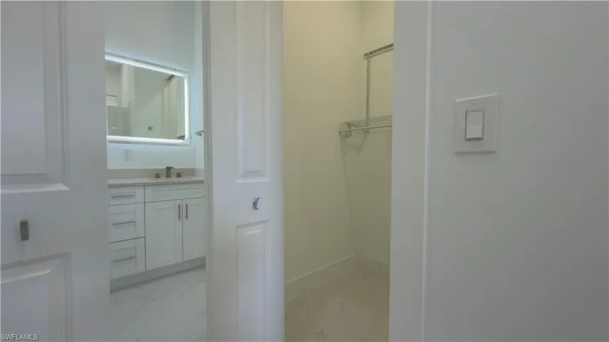 Bathroom featuring vanity and light marble finish flooring