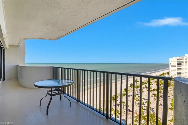 Balcony featuring view of water and beach