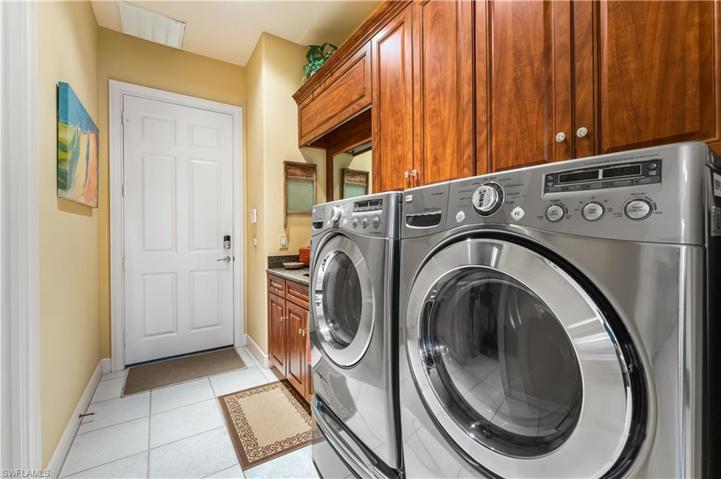 Landry room offers a deep tub and extra storage cabinetry. Full size front loading washer & dryer.