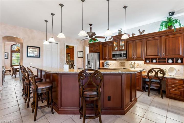 Custom cherry wood cabinetry with uplighting, underlighting, in cabinet lighting,tumbled marble backsplash, granite countertops,work spaceSS appliances.